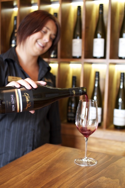 A Gibbston Valley Winery staff member pours a glass of their premium wine  